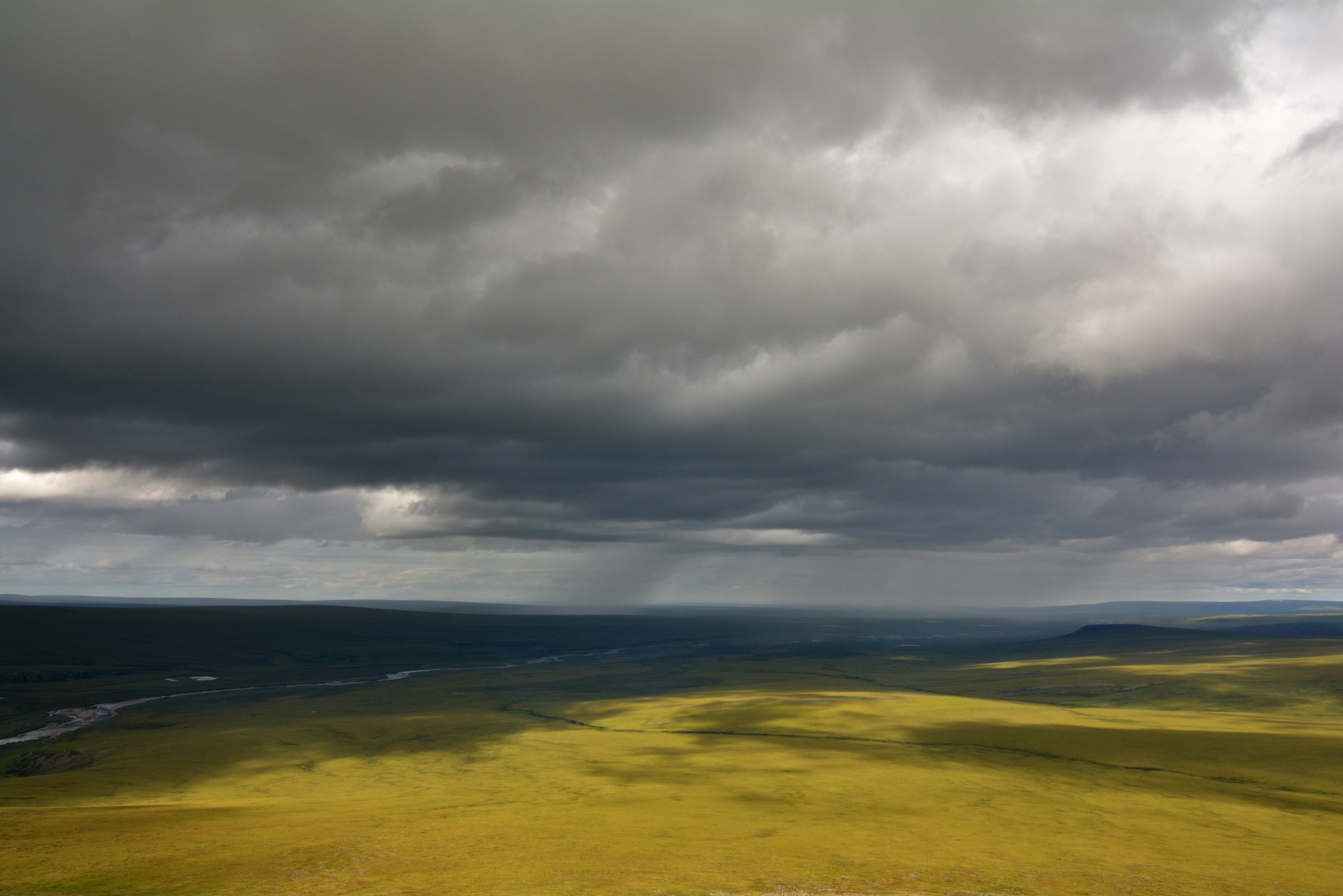 Dark clouds loom over a flat land.